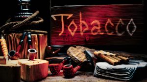 Port St Lucie smoke shop display with tobacco pipes, cigars, and wooden sign illuminated in warm rustic setting.
